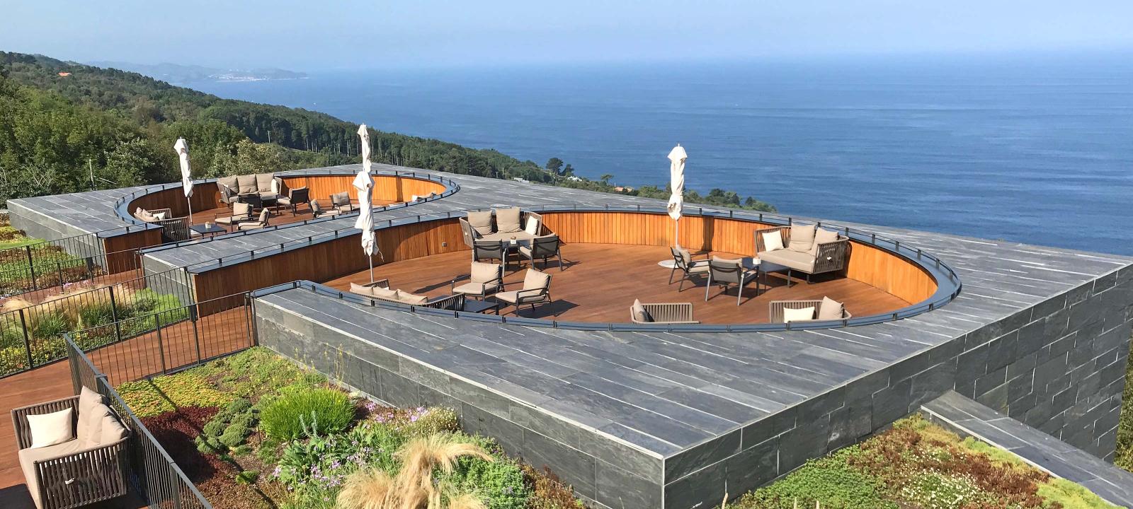 Cubierta jardín con zona de asientos de madera y vista al mar