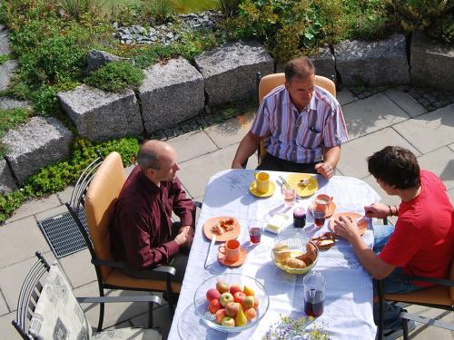 La gente desayuna en una terraza con una rejilla de drenaje