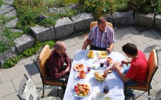 La gente desayuna en una terraza con una rejilla de drenaje