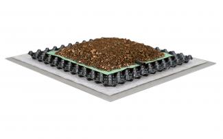 Sistema “Cubierta verde extensiva con riego integrado”: "Comunidad de plantas "Tapizante floral" (no en la imagen), Zincoterra “Floral” aprox. 8 cm, Tubería por goteo fijada en el fieltro de distribución de agua AF 300, Elemento de drenaje, p. ej. Floradrain® FD25-E, Manta protectora y retenedora SSM 45, Impermeabilización antirraíz Sistema “Cubierta verde extensiva con riego integrado”